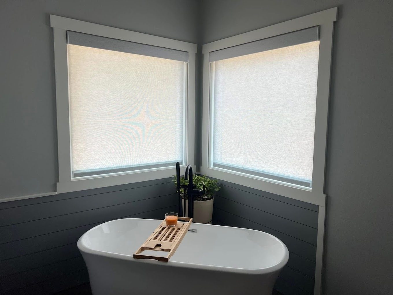 Soft light-filtering shades in a corner bathroom